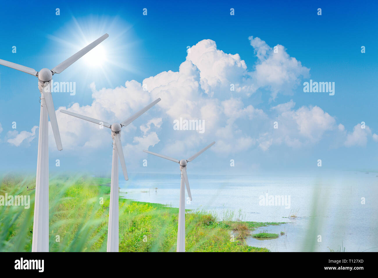 Fila di turbine eoliche con cielo verde ambiente energia pulita generatore di potenza concetto. Foto Stock