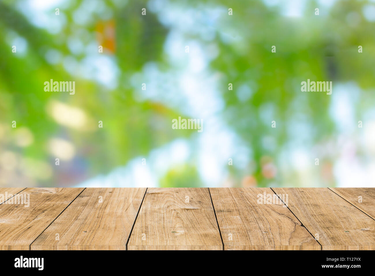 Tavolo in legno con sfocatura dello sfondo verde per i prodotti modello spazio pubblicitario. Foto Stock