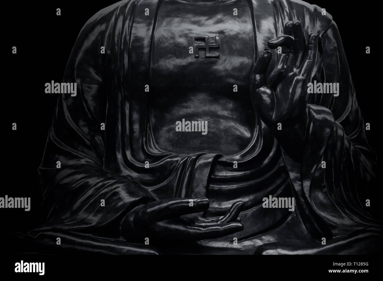 Closeup mano di pietra nera statua di Buddha nel tempio asiatico. Foto Stock