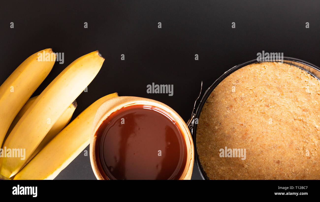 Concetto di cibo rendendo il dessert fatti in casa torta banoffee su sfondo nero Foto Stock