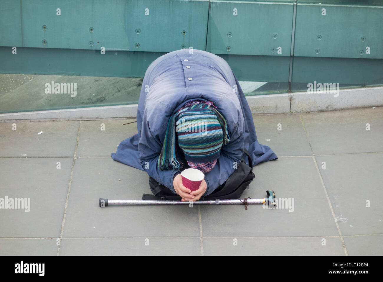 Una donna prostatica dell'Europa dell'Est che mendica fuori dal Tate Modern sul Millenium Bridge, Londra, Inghilterra, Regno Unito Foto Stock