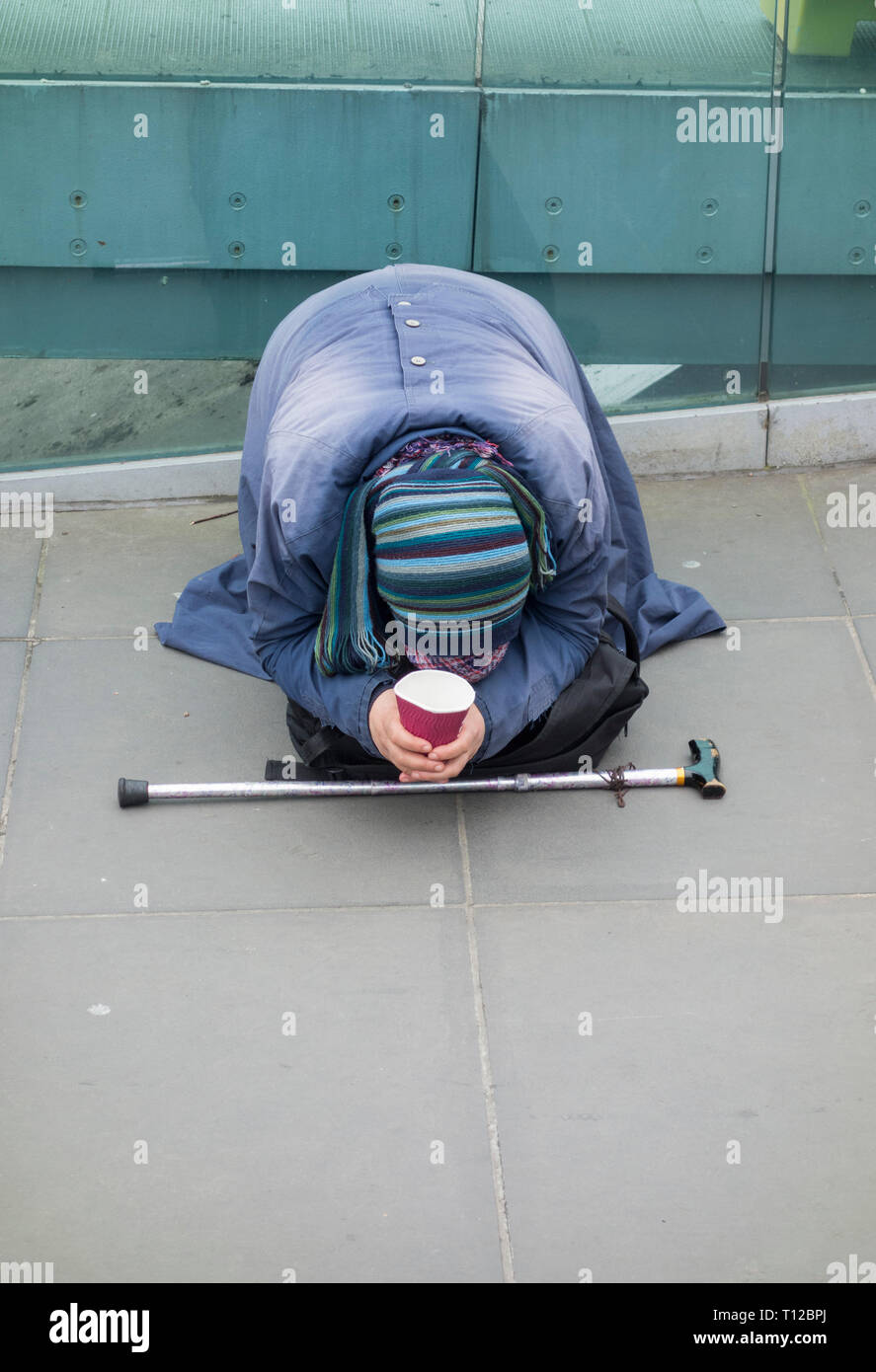 Una prostata Europeo Orientale donna mendicare al di fuori della Tate Modern sul Millennium Bridge, London, Regno Unito Foto Stock