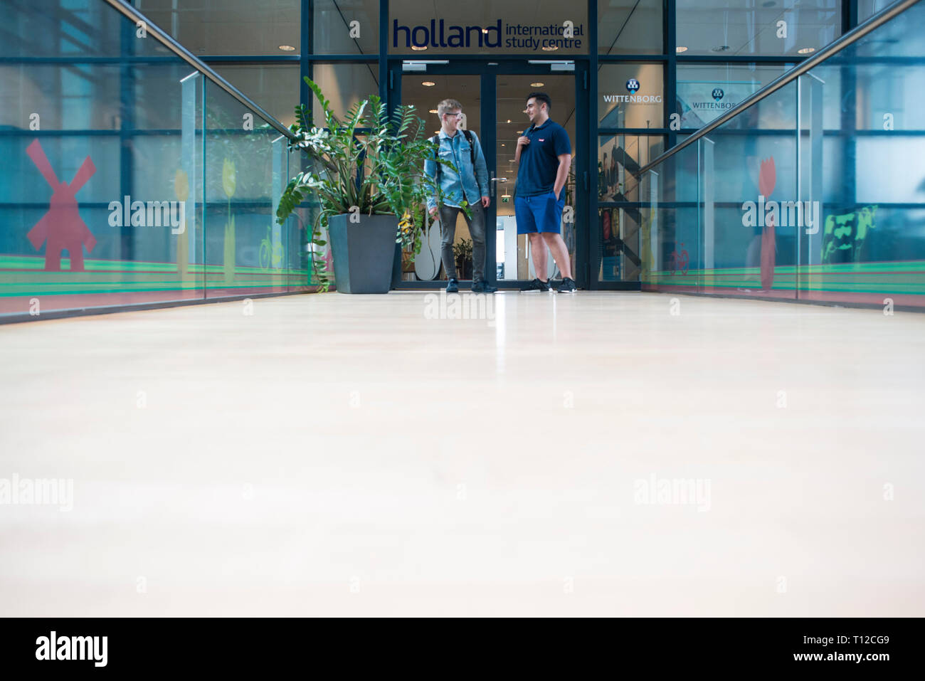 Maschio di studenti internazionali nel moderno e luminoso corridoio del loro collegio. Foto Stock