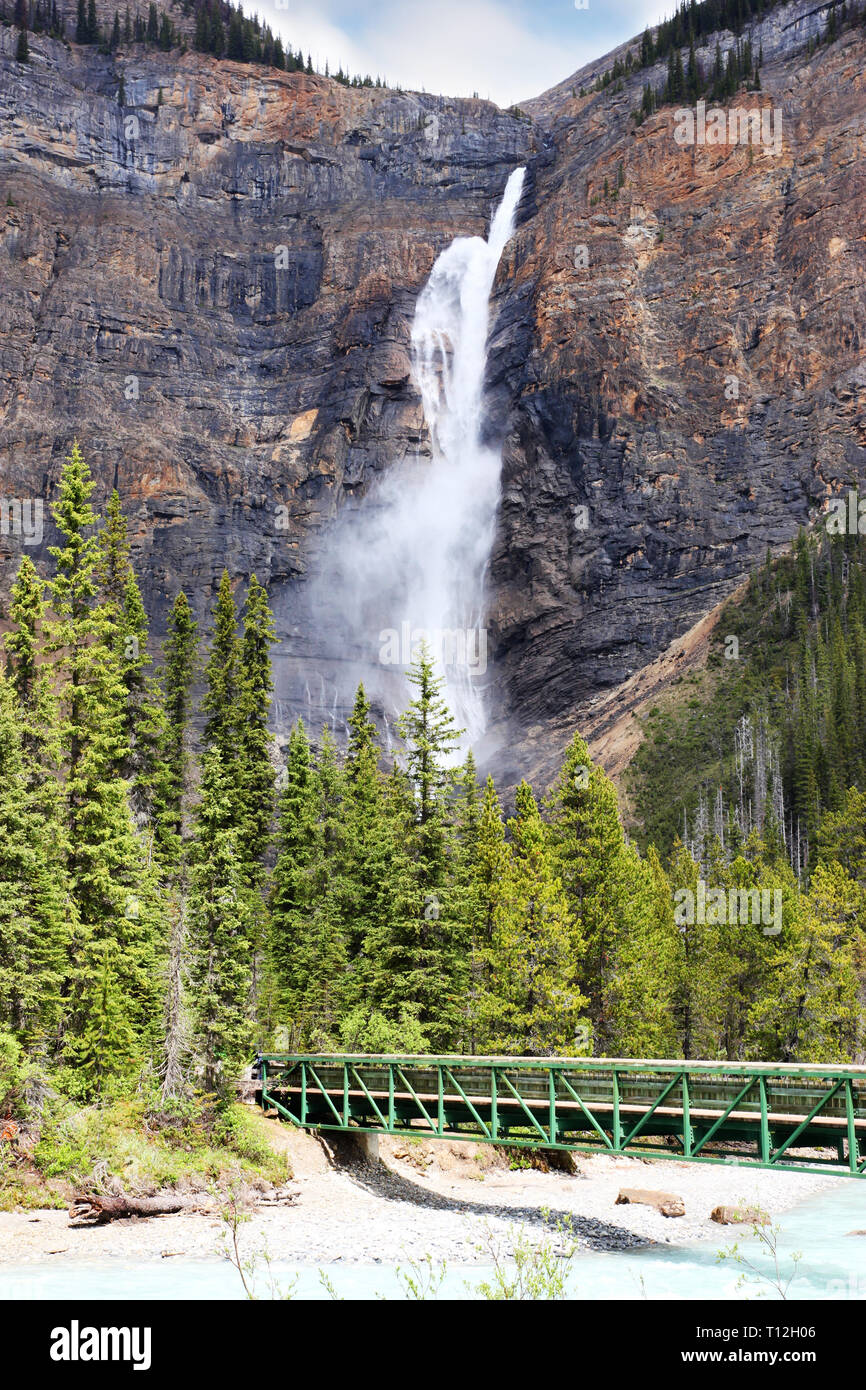 Il Footbridge attraverso Fiume Kicking Horse alla potente delle Cascate di Takakkaw nel Parco Nazionale di Yoho vicino campo, British Columbia, Canada. Il Ghiacciaio-nutriti ad acqua Foto Stock