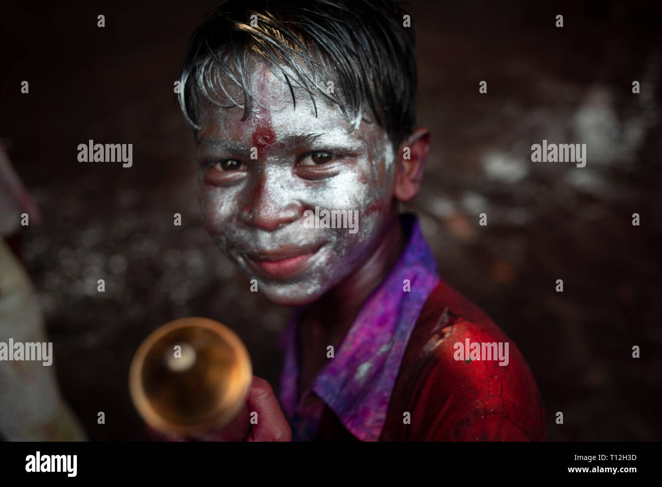 Un ragazzo con un argento faccia dipinta visto che posano per una foto durante la celebrazione. Holi noto come il festival di colore è un antico indù festival di primavera che ora è celebrato in molti paesi e il Bangladesh è tra quelli. Le persone organizzano molti programmi di ballo e giocare con il colore in polvere e acqua per esprimere e condividere la loro felicità con ogni altro. Foto Stock