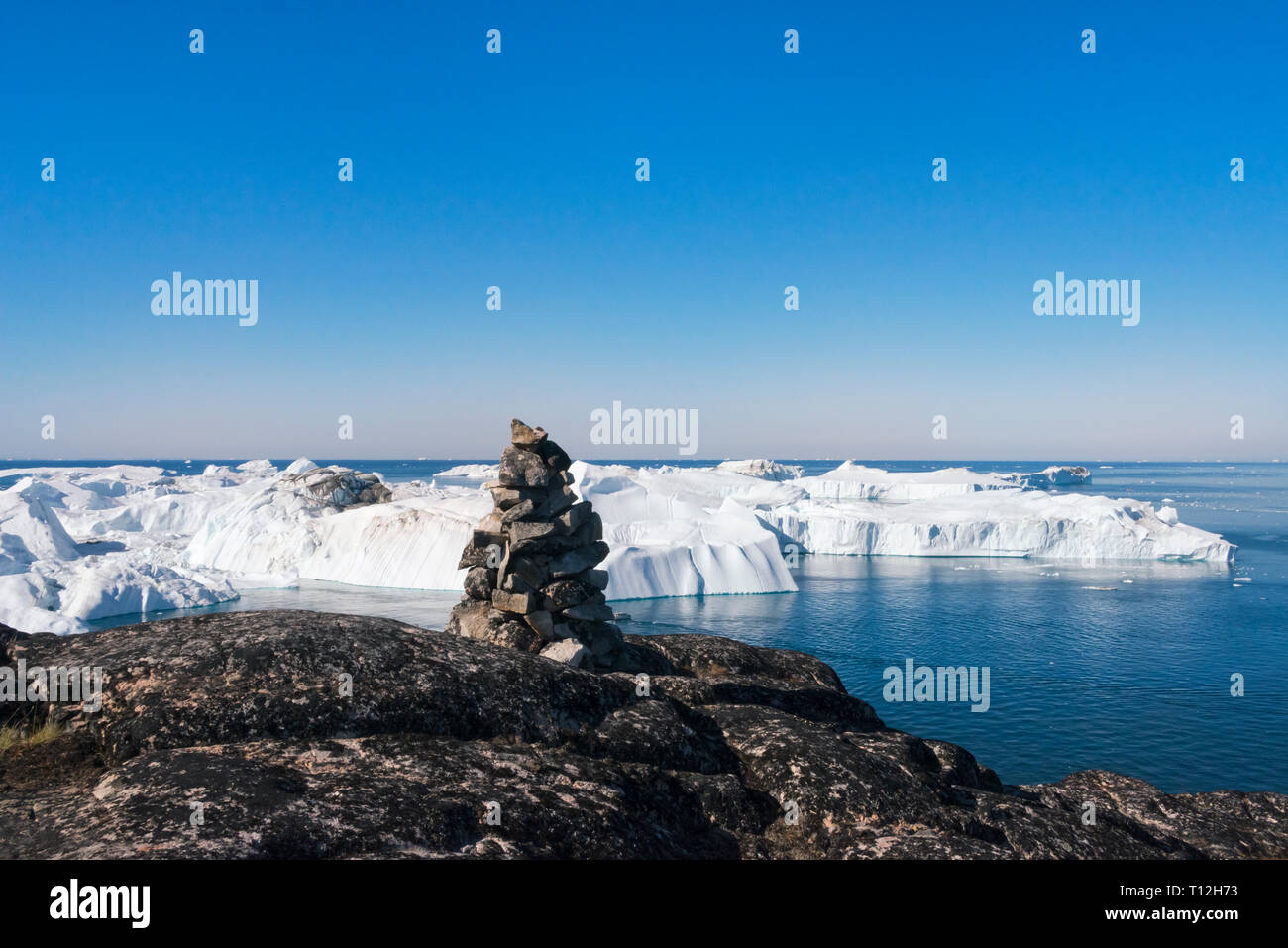 Cairn (mucchio di pietre) affacciato su iceberg di Sermermiut, Ilulissat Foto Stock