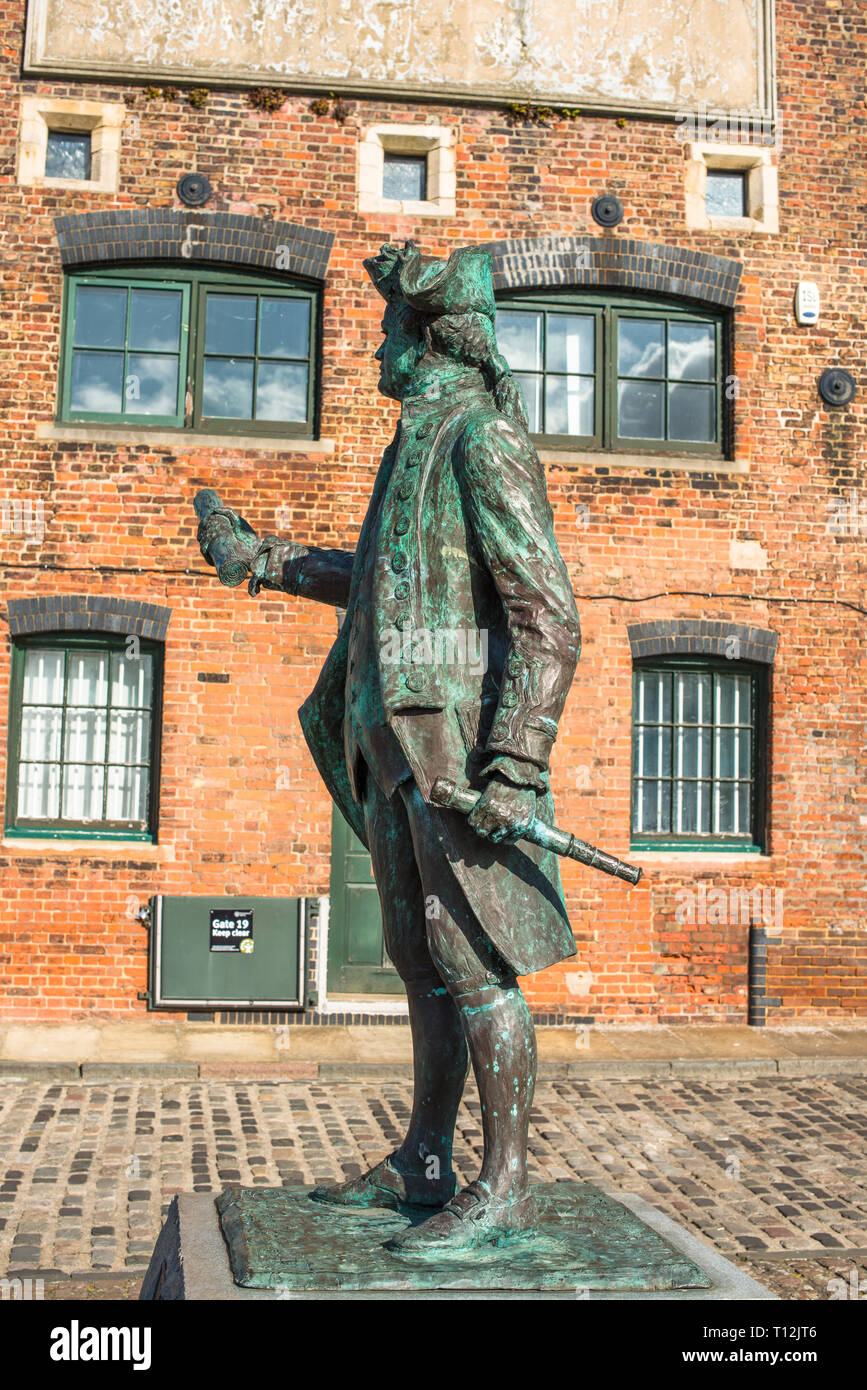 Statua di il Capitano George Vancouver contro lo sfondo di un vecchio magazzino, Hereford quay, King's Lynn, West Norfolk, Inghilterra, Regno Unito. Foto Stock