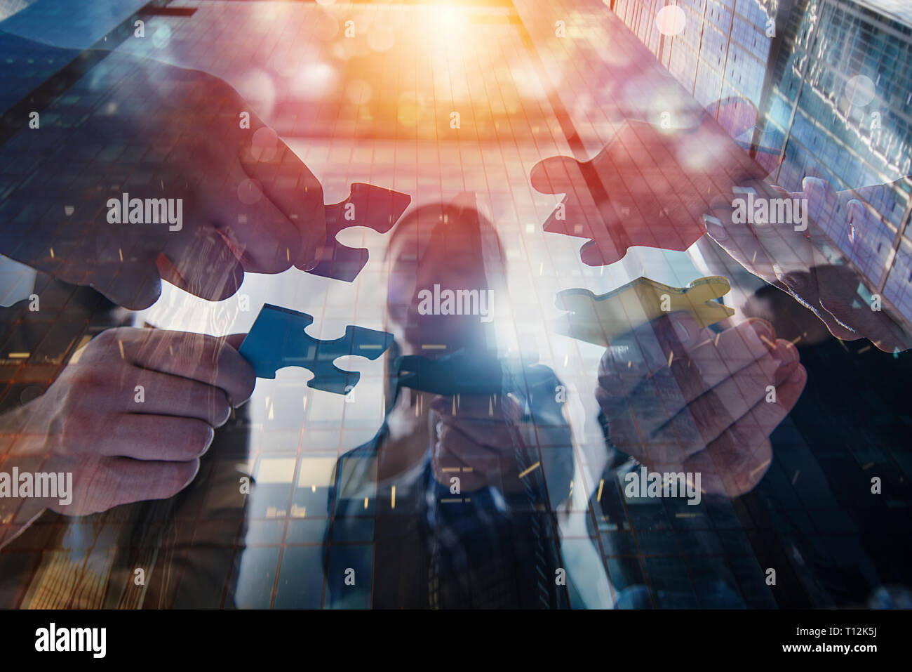 La gente di affari unire i pezzi del puzzle. Concetto di partnership e il lavoro di squadra. doppia esposizione Foto Stock