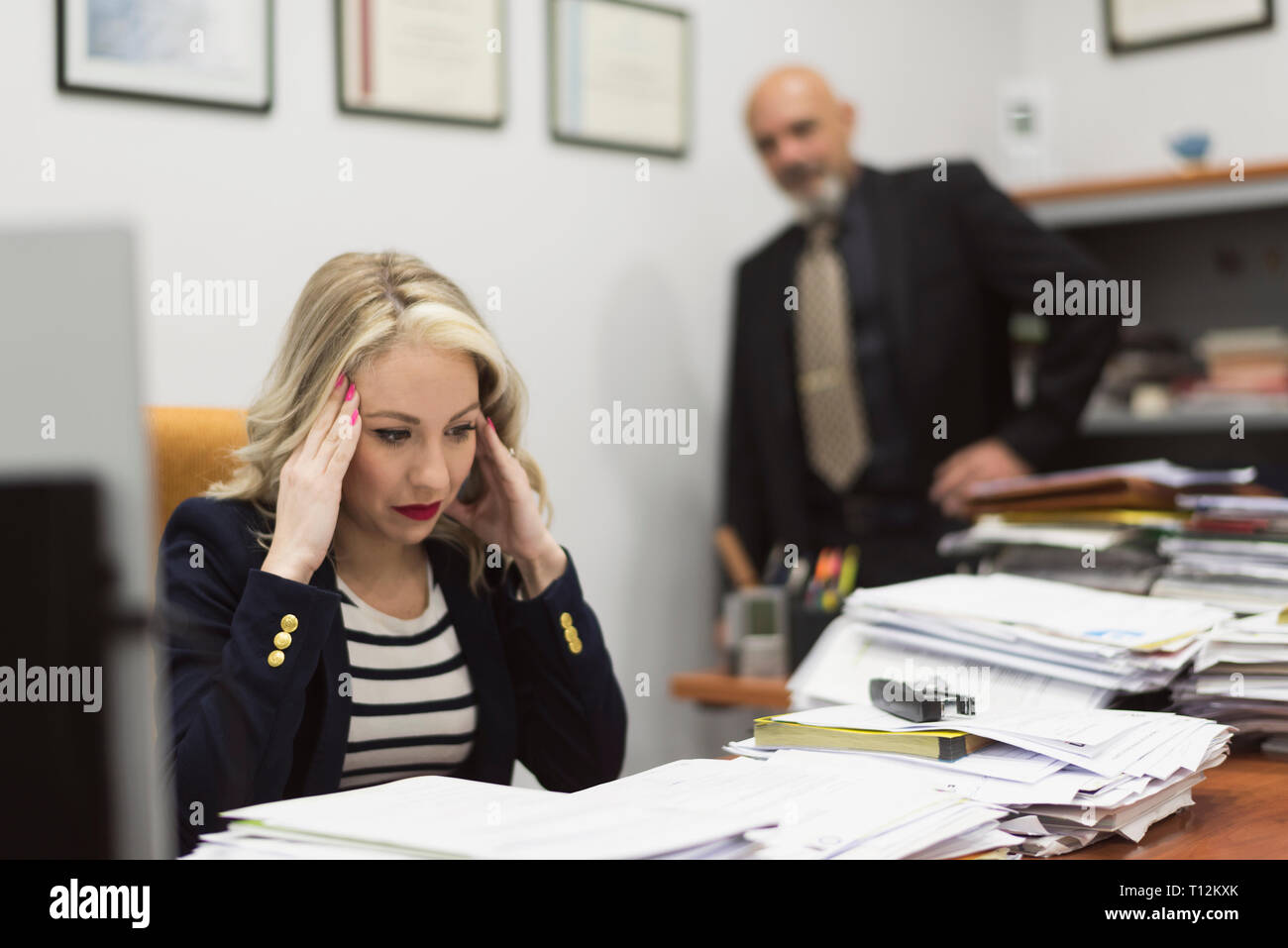 Femmina di lavoratore di ufficio ha sottolineato prima di un grande carico di documenti e lavori di ufficio Foto Stock