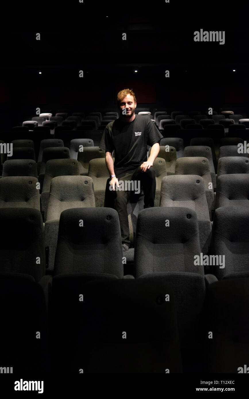 Un elemento maschio di personale si siede in un auditorium vuoto del Duca di Yorks movie theater in Brighton Foto Stock