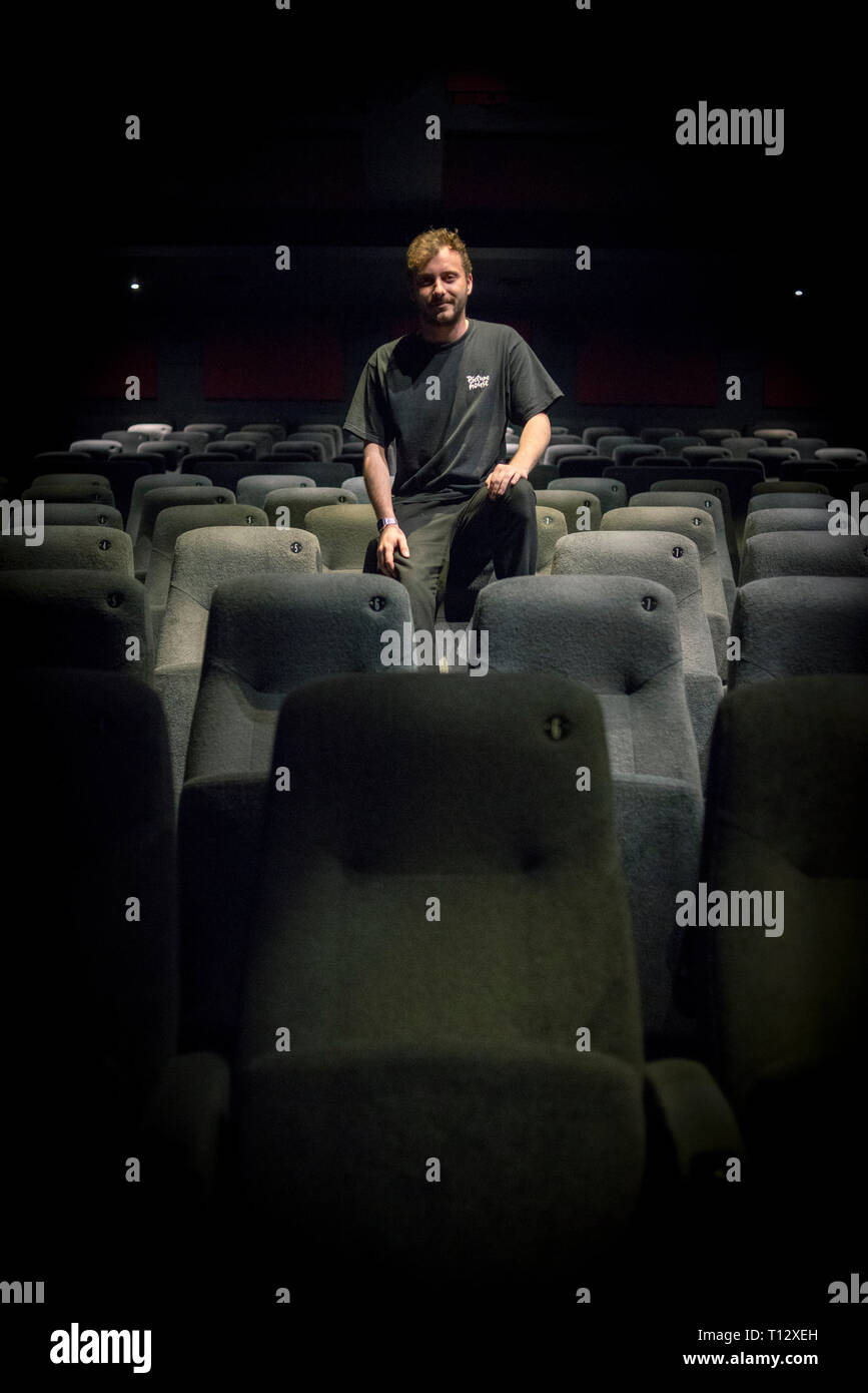Un elemento maschio di personale si siede in un auditorium vuoto del Duca di Yorks movie theater in Brighton Foto Stock