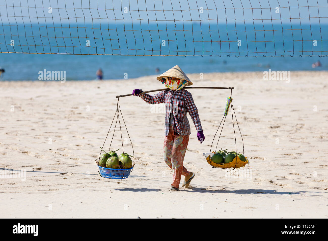 NAM TIEN, VIETNAM - Febbraio 21, 2018: frutta e bere il venditore a piedi in una spiaggia di Nam Tien, Vietnam Foto Stock