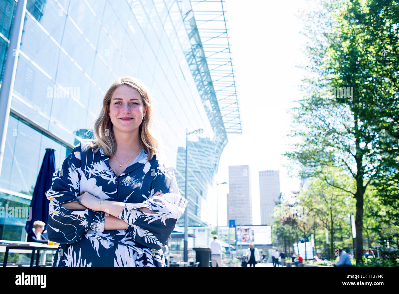 Un giovane fiducioso business donna si erge al di fuori in un business park di Amsterdam Foto Stock