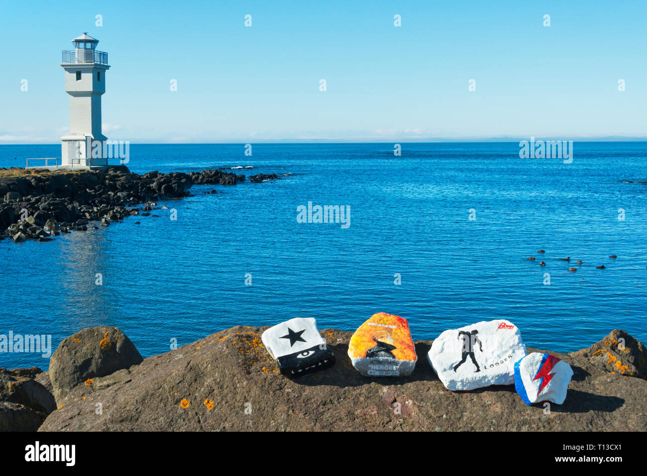 Pietre dipinte e il faro sulla spiaggia, Akranes, Islanda Foto Stock