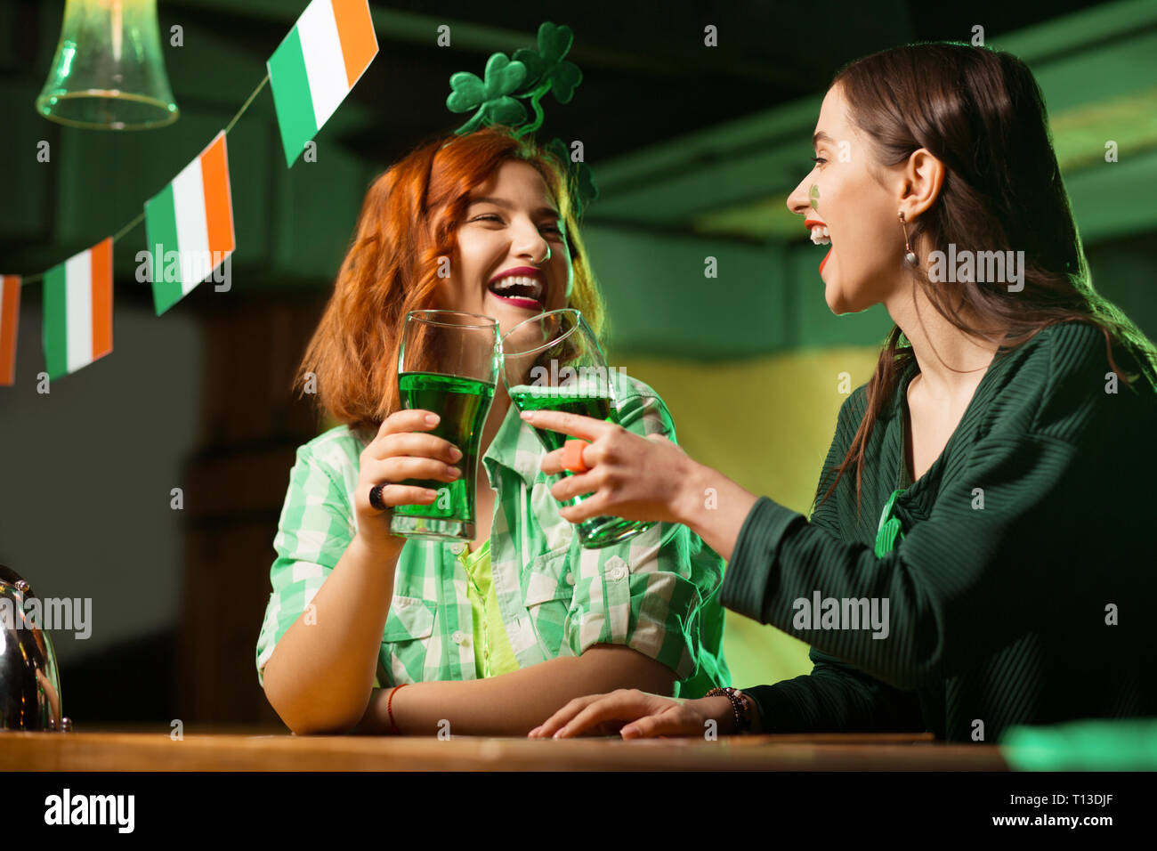 I Capelli rossi ragazza piuttosto di un verde camicia a scacchi e una  ragazza con una maschera a bere birra verde Foto stock - Alamy