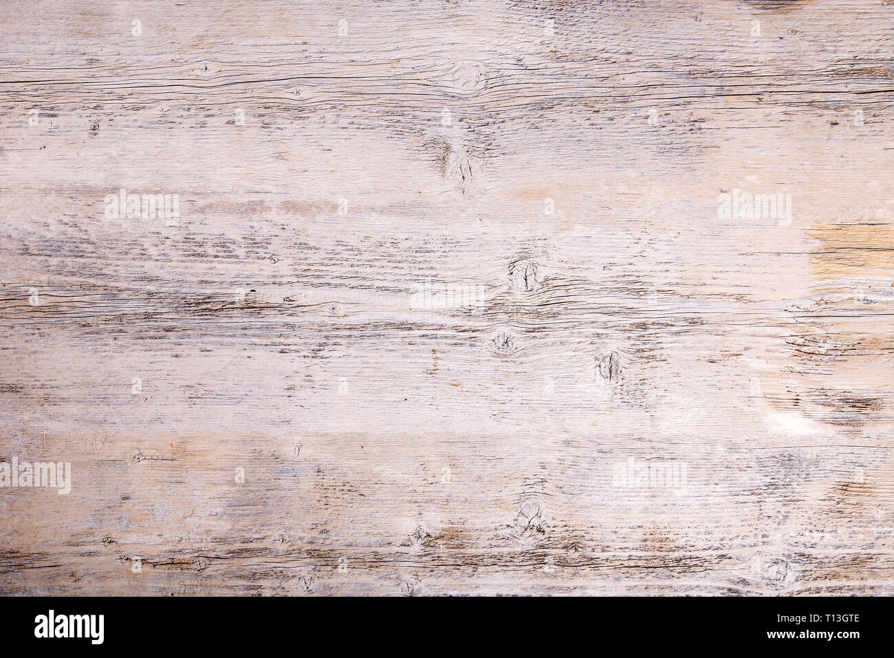 Sbucciare la vernice su un vecchio pavimento in legno. Bianco sullo sfondo di legno Foto Stock