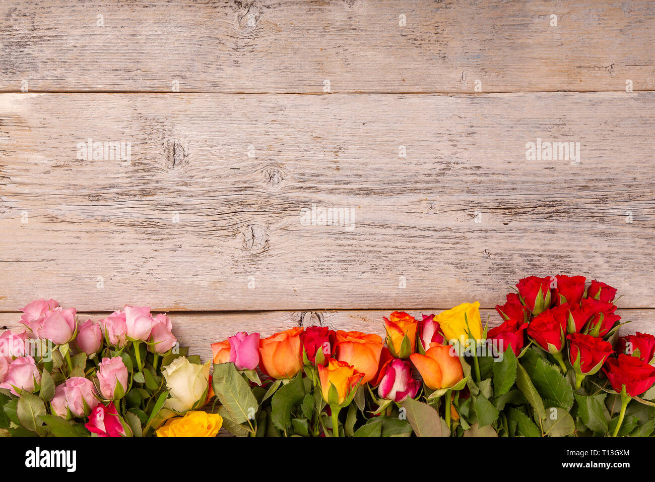 Colorata cornice floreale con spazio per la copia su sfondo di legno Foto Stock