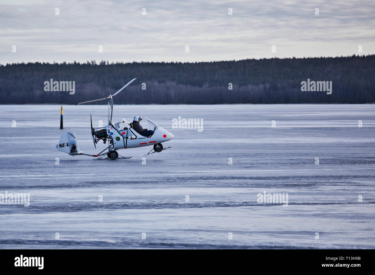 Di piccole dimensioni e di colore bianco elicottero decolla da ghiaccio del Lago Malaren, Sigtuna, Svezia e Scandinavia Foto Stock