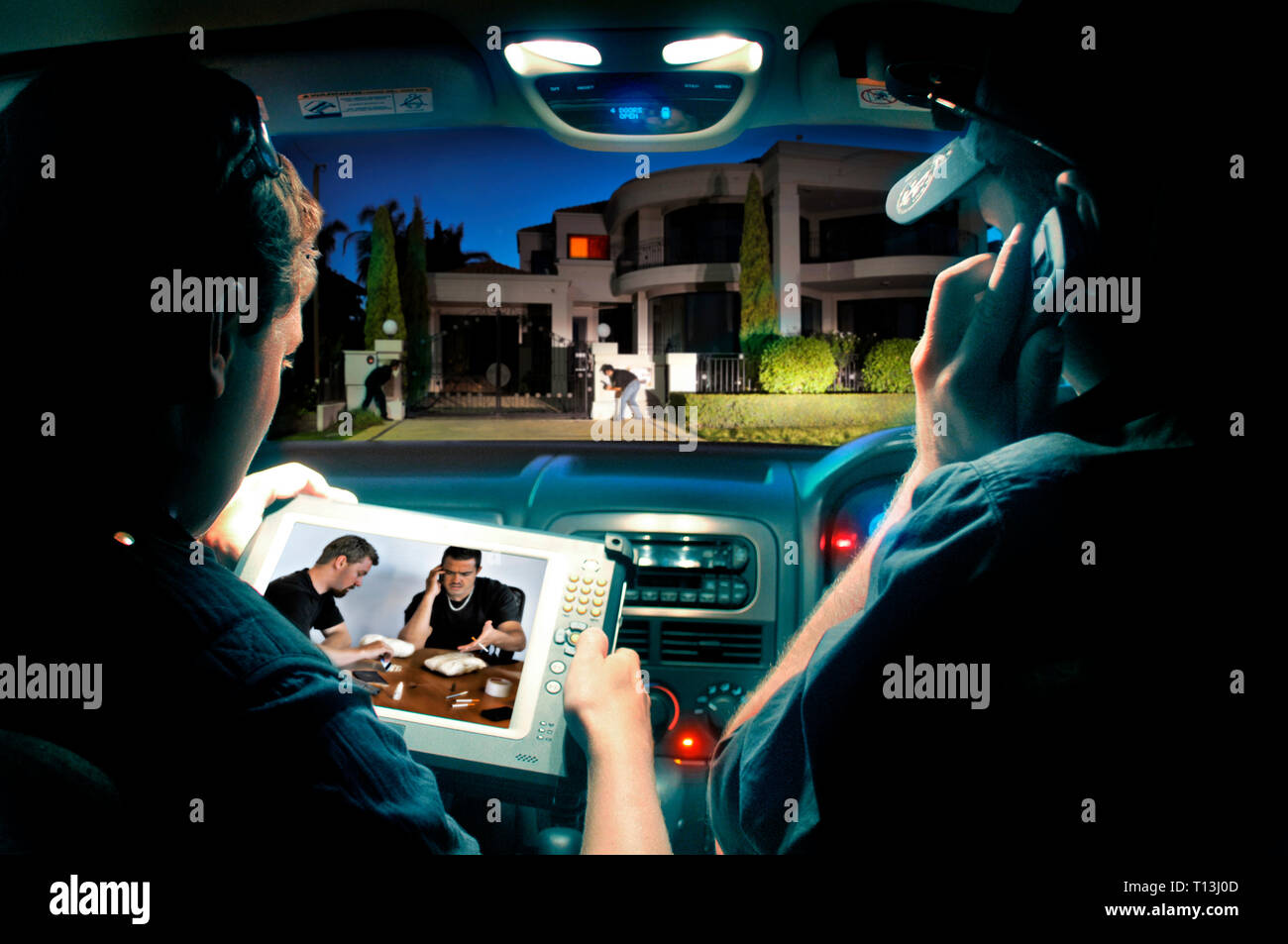 All'interno della vista auto della polizia utilizzando una mano tenuta compressa per monitorare i trafficanti di droga in una casa vicina. Un drone relè immagini per il tablet. Foto Stock