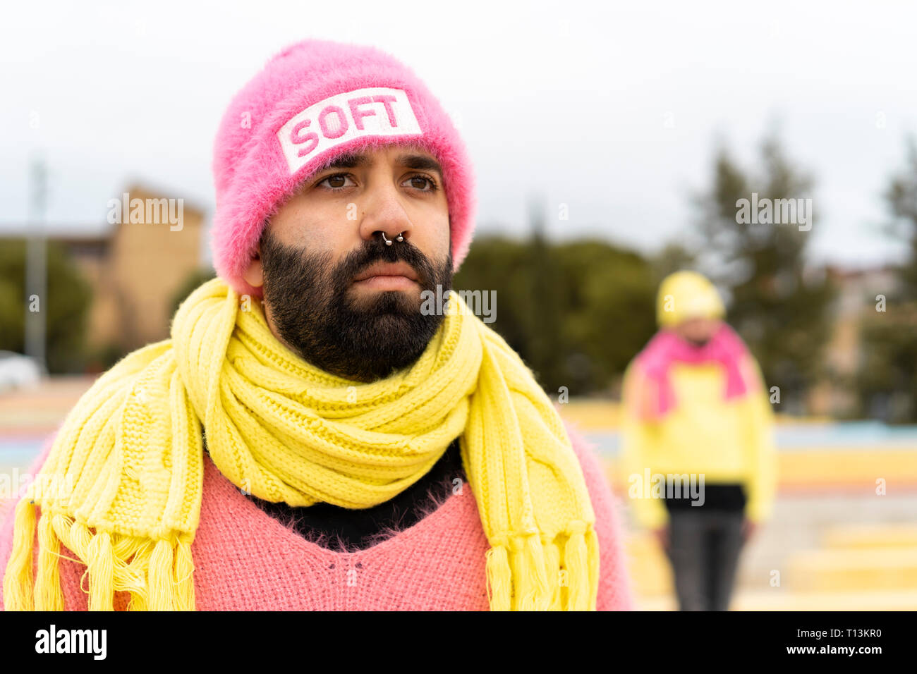 Ritratto di barbuto gay con piercing per il naso indossando cappello rosa con la parola 'soft' Foto Stock