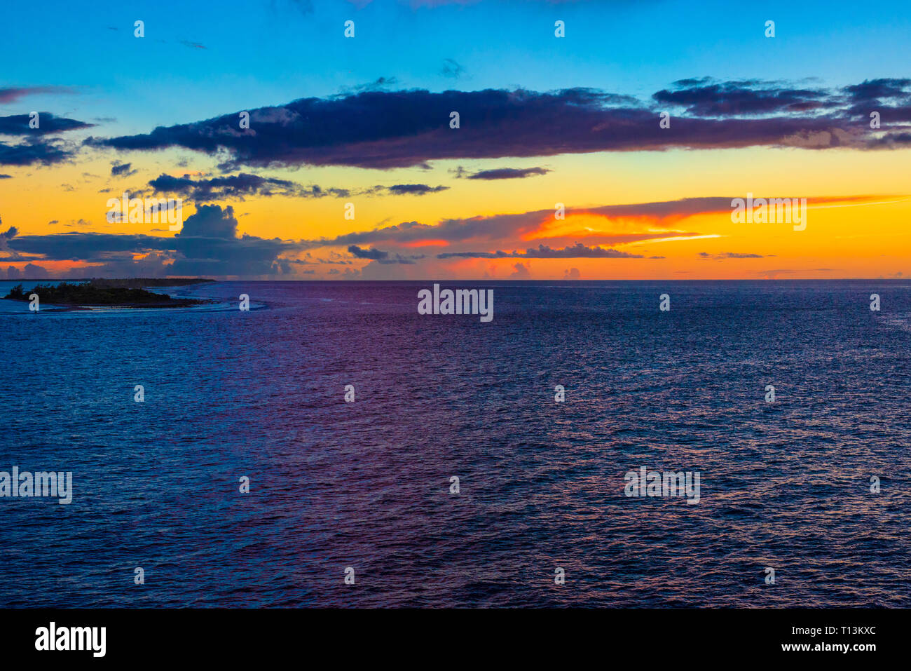 Il cielo diventa rosso, arancione, giallo e blu come il sole tramonta su Polinesia. Foto Stock