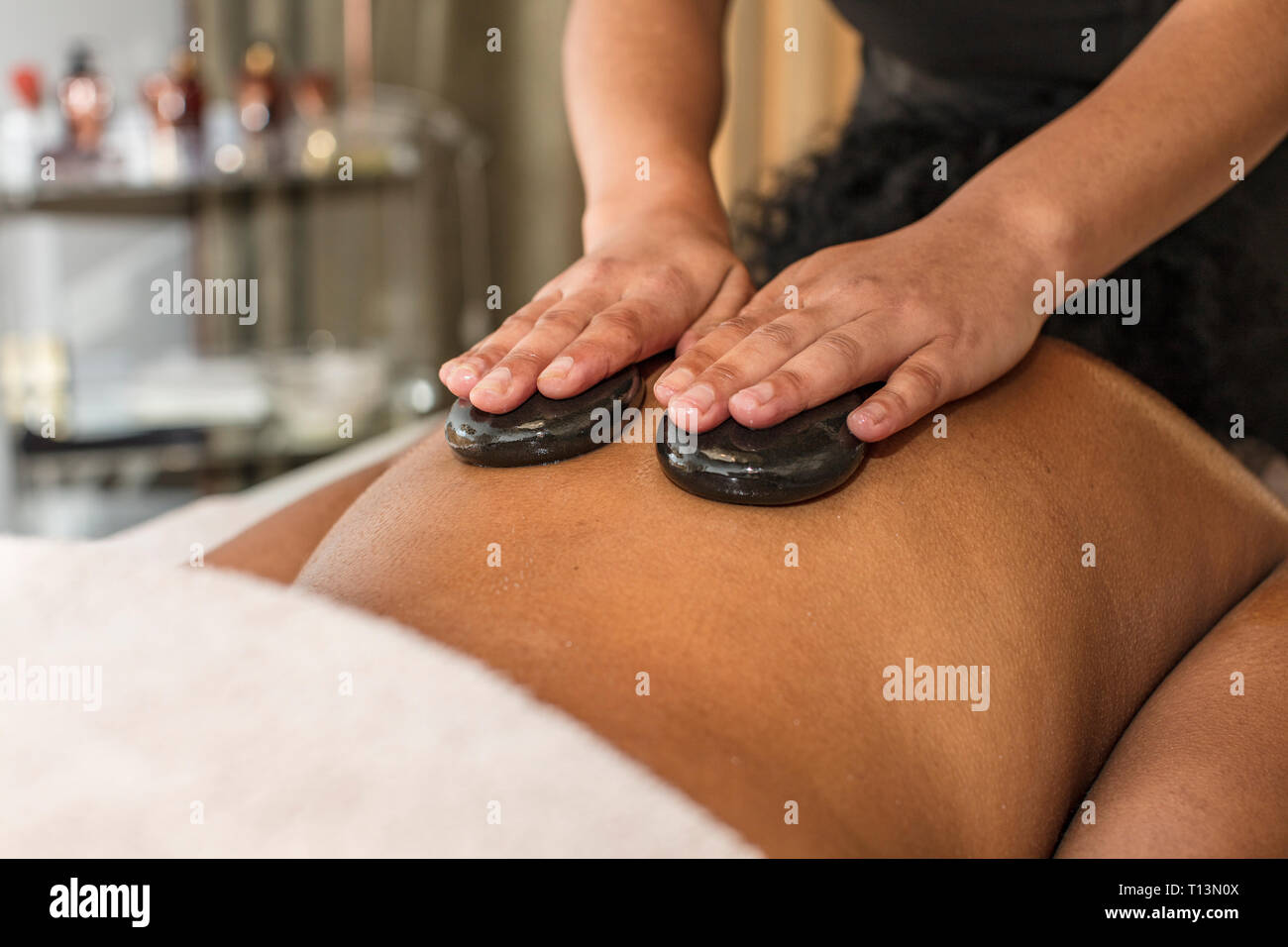 Donna ricevere un massaggio hot stone in una spa Foto Stock
