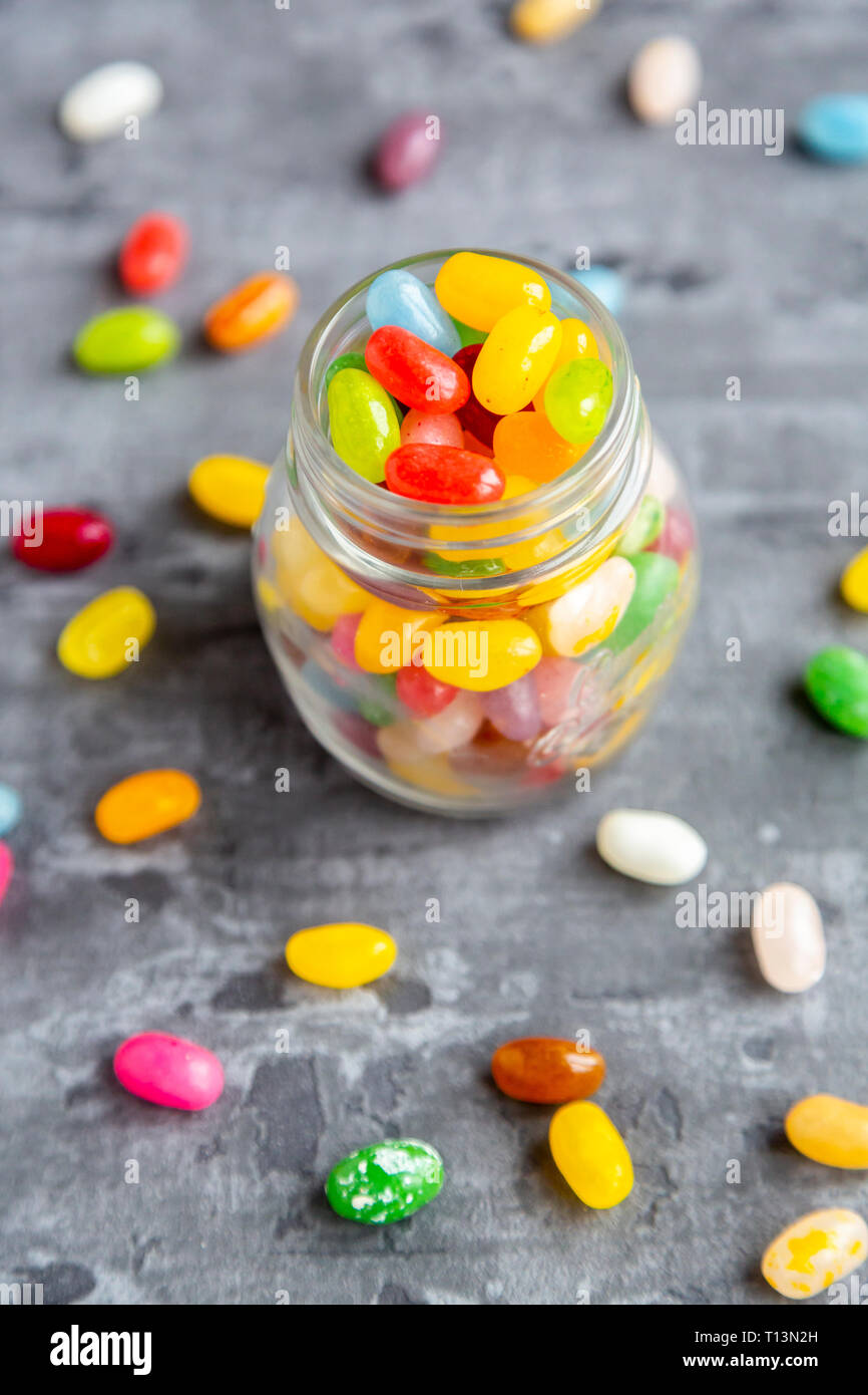 Di vetro colorato jellybeans dolce su sfondo grigio Foto Stock