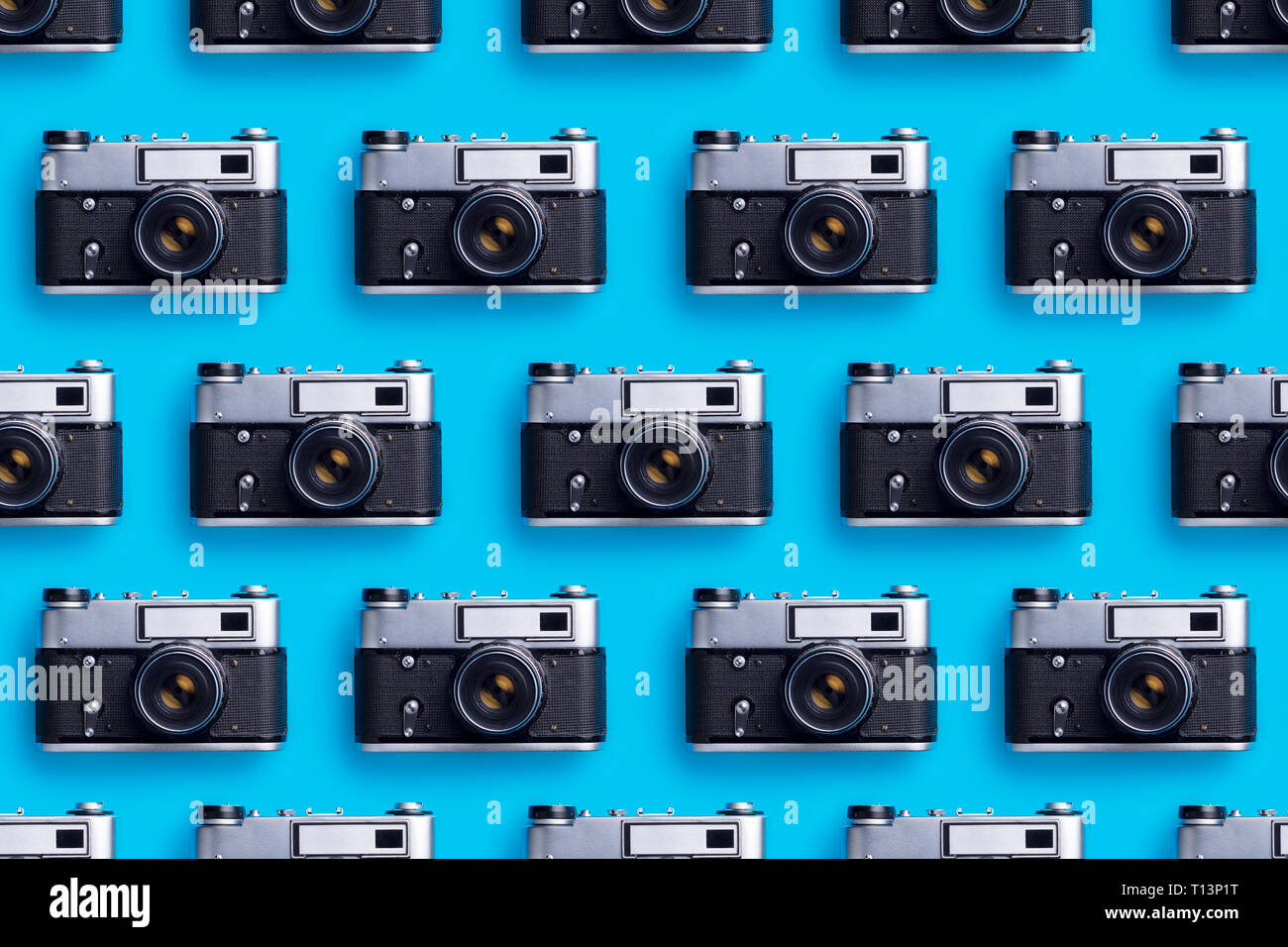 Le macchine fotografiche organizzate in una fila su sfondo blu Foto Stock