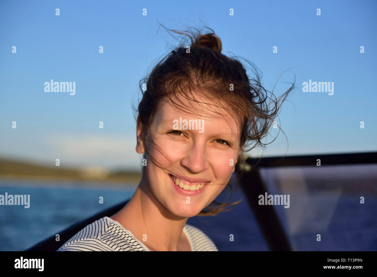 Ritratto di sorridente ragazza su una barca in mare Foto Stock