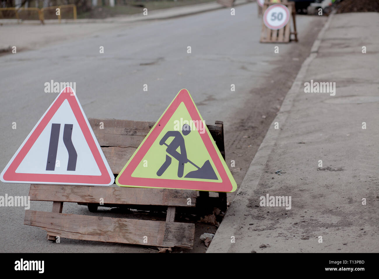 Segnaletica stradale, deviazione, riparazione su strada su strada, sfondo carrello escavatore e foro di scavo. Foto Stock