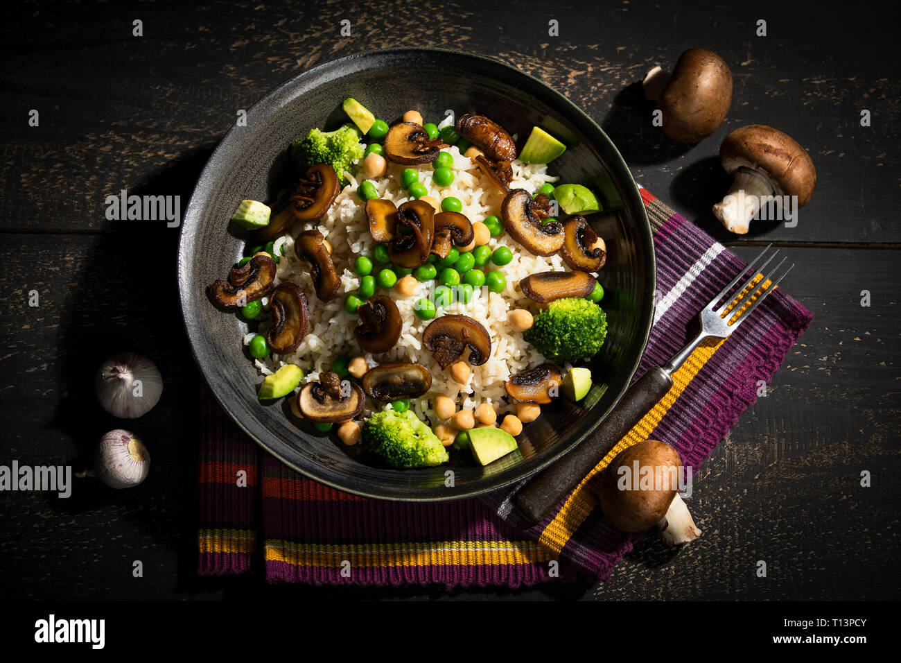 Piatto vegano: naturale riso con champignon, piselli, ceci, avocado e broccoli Foto Stock