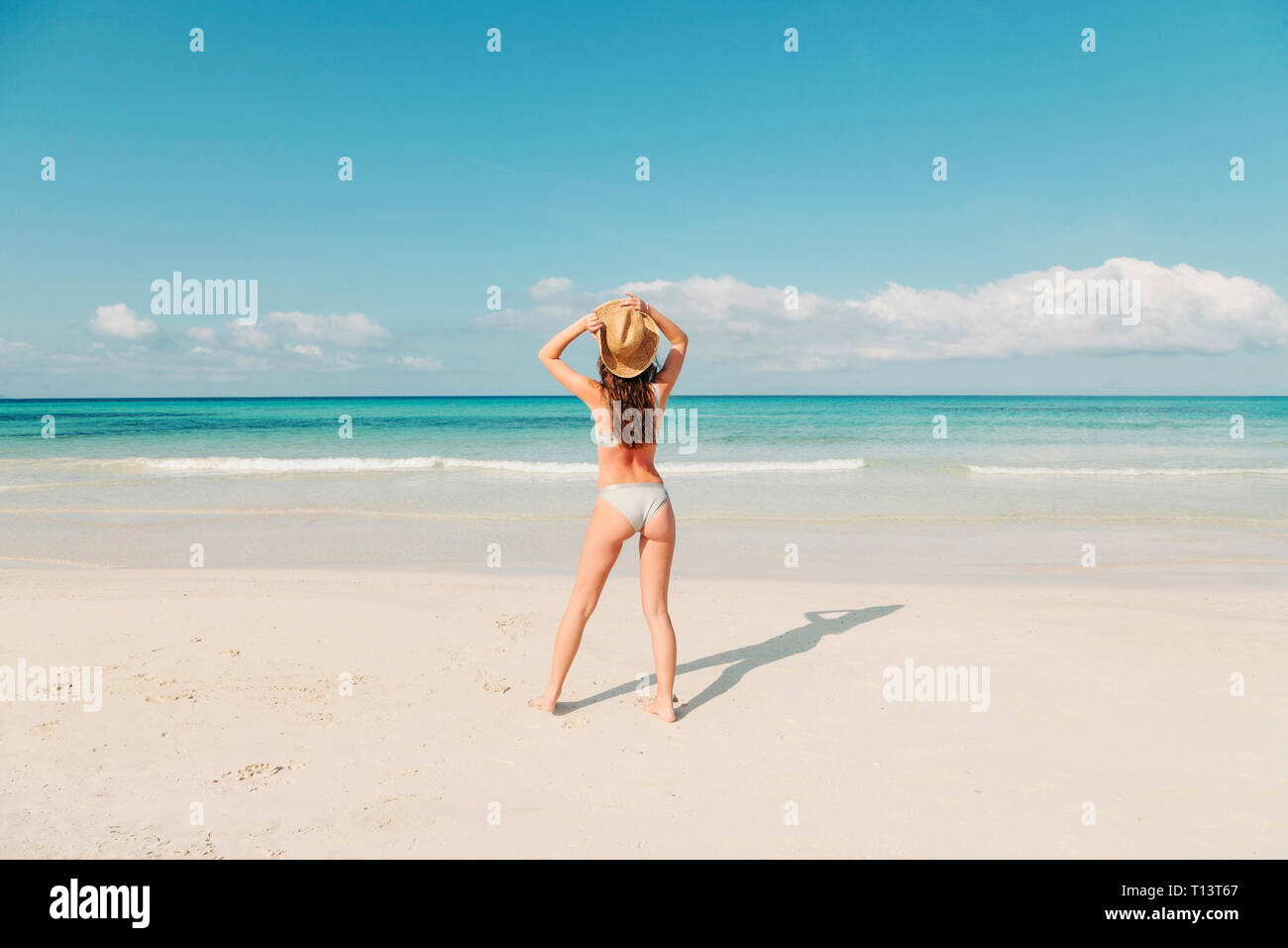 Spagna, Mallorca, vista posteriore di una giovane donna su vacanze a piedi sulla spiaggia Foto Stock