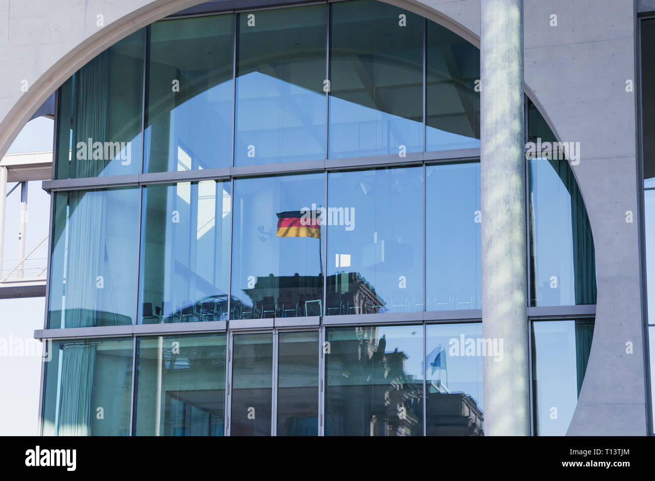 Germania, Berlino, Regierungsviertel, riflesso del palazzo del Reichstag e la bandiera tedesca in Marie-Elisabeth-Lueders-Building, mirroring in facciata di vetro Foto Stock