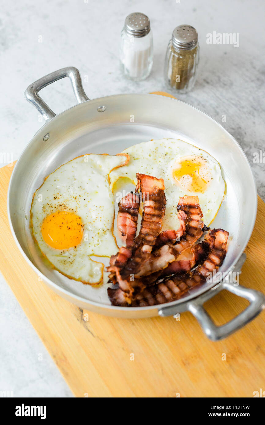 Uova fritte e bacon in padella Foto Stock