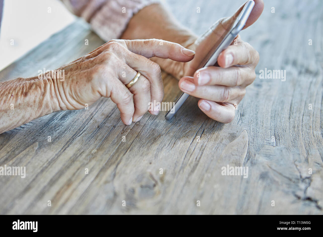Donna con le mani in mano utilizza lo smartphone, close-up Foto Stock
