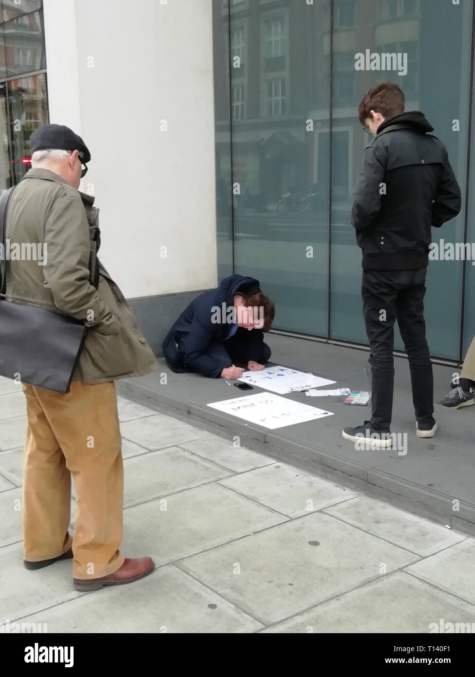 Londra, Regno Unito. 23 mar 2019. Voto popolare marzo, metterlo al popolo Marzo, Londra centrale, oggi, 2019/03/23, inizia a Park Lane, termina in piazza del Parlamento, dimostrante marcher prepara il suo banner su una strada marciapiede marciapiede con penne di colorazione mentre passer guardando su Foto Stock