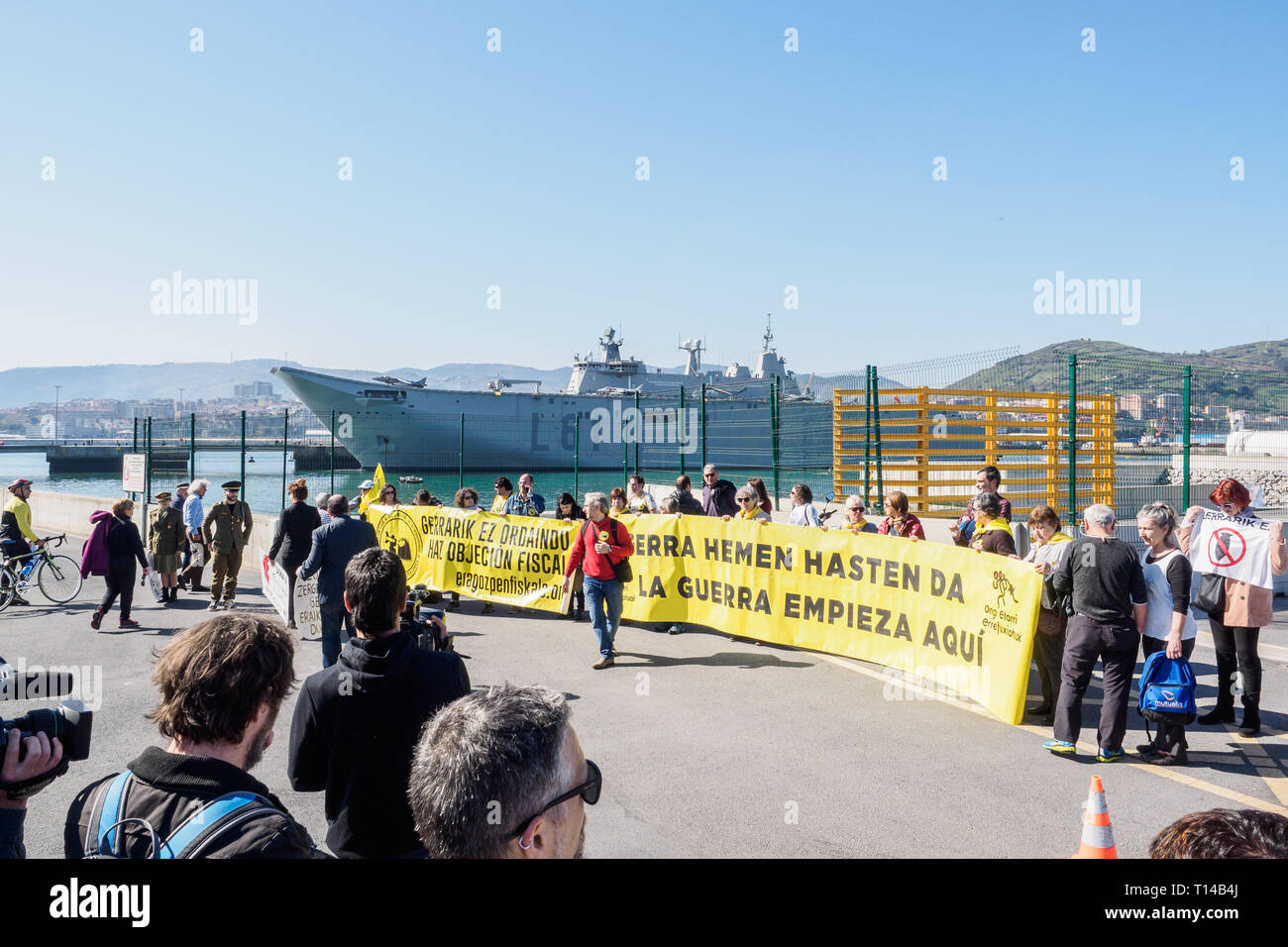 BILBAO, Spagna - marzo / 23/2019. Persone che protestano l arrivo della portaerei della Marina spagnola Juan Carlos I nel porto di Bilbao durante Foto Stock