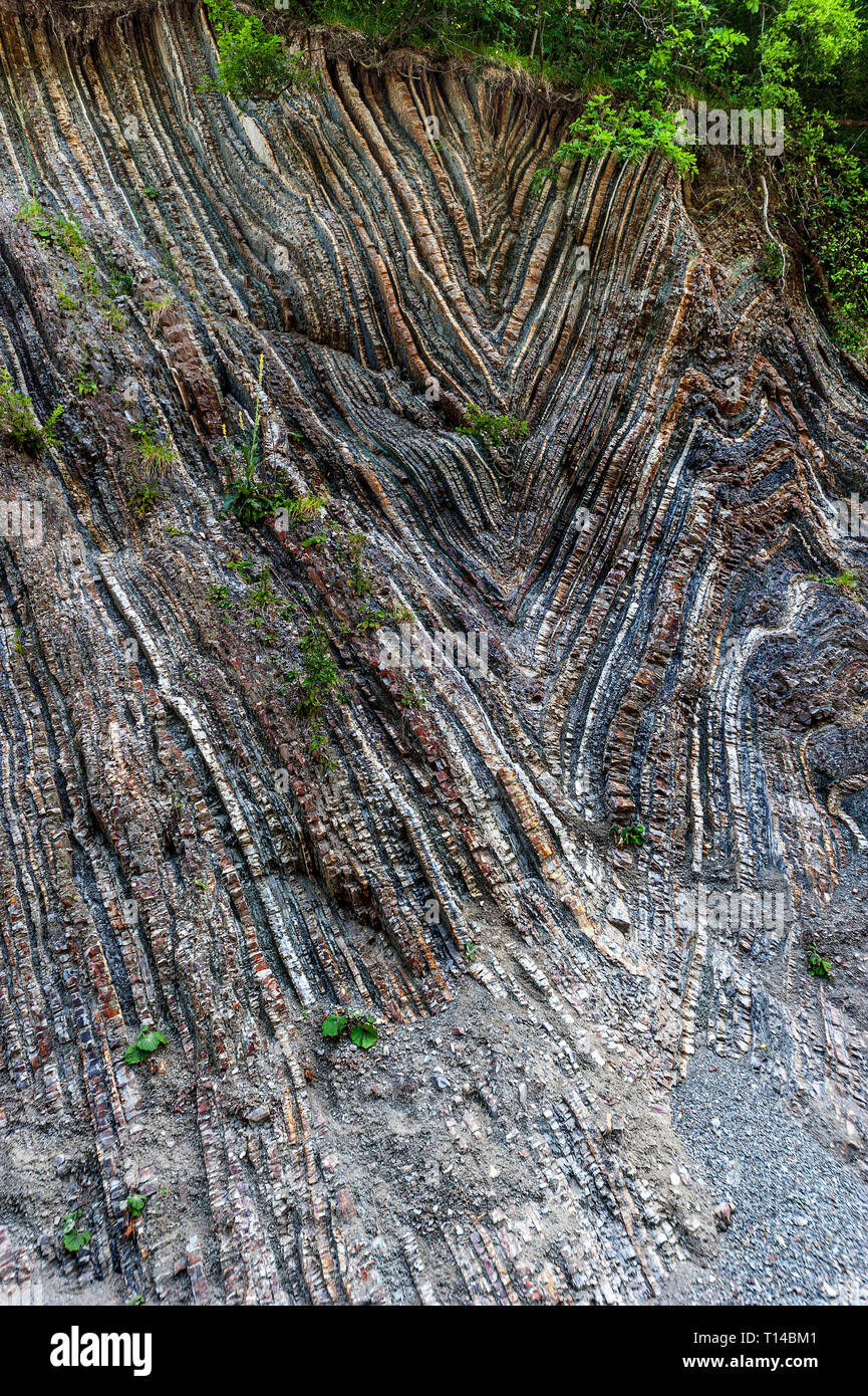 Russia, Regione Krasnodar, la strada a Sochi. La bizzarra geometria dei monti del Caucaso. Multi-colore di strati di calcare in ardesia. Foto Stock