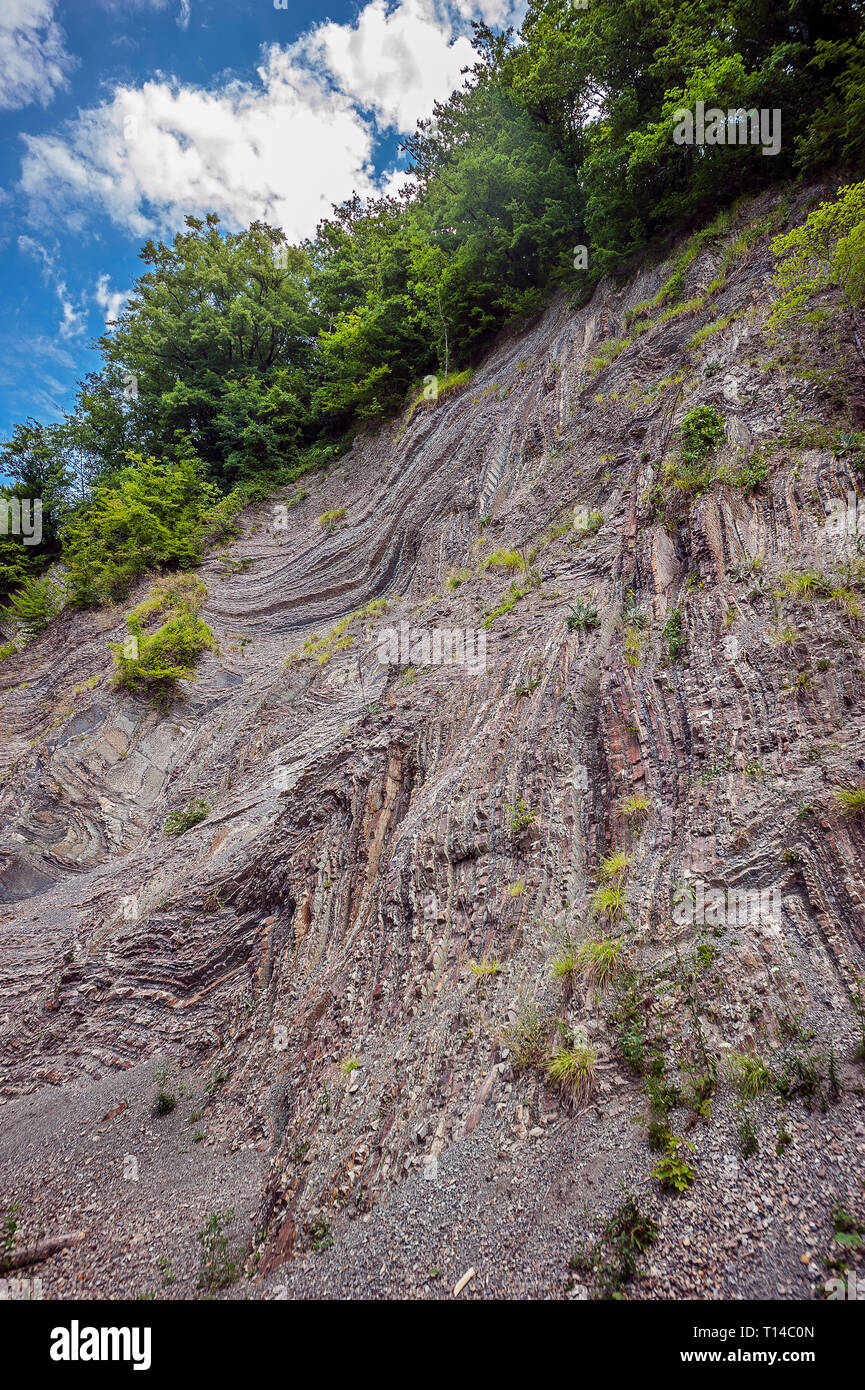 Russia, Regione Krasnodar, la strada a Sochi. La bizzarra geometria dei monti del Caucaso. Multi-colore di strati di calcare in ardesia. Foto Stock