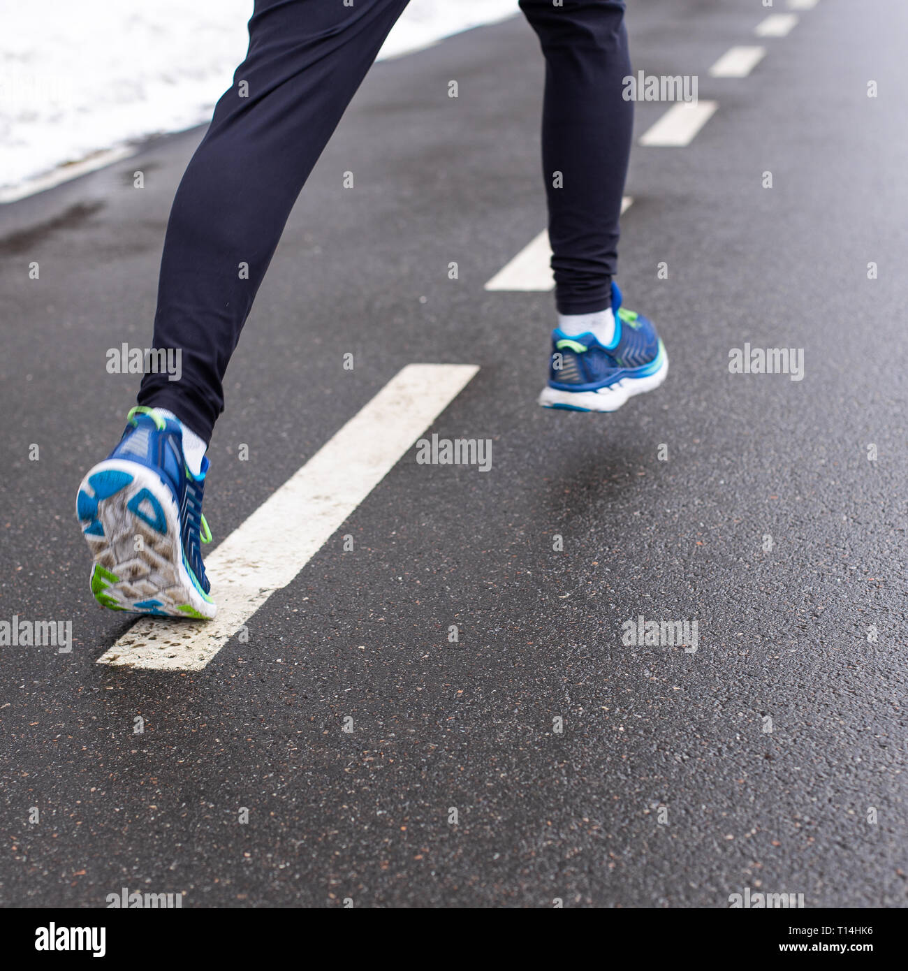 Gambe di uomo che corre in calzature sportive e pantaloni Foto Stock