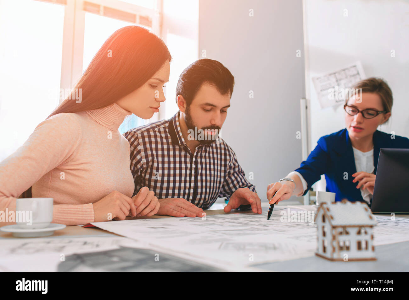 Famiglia giovane giovane acquisto affitto immobili . Agente che conferisca la consultazione per uomo e donna. Firma contratto per acquisto di casa o appartamento o apar Foto Stock