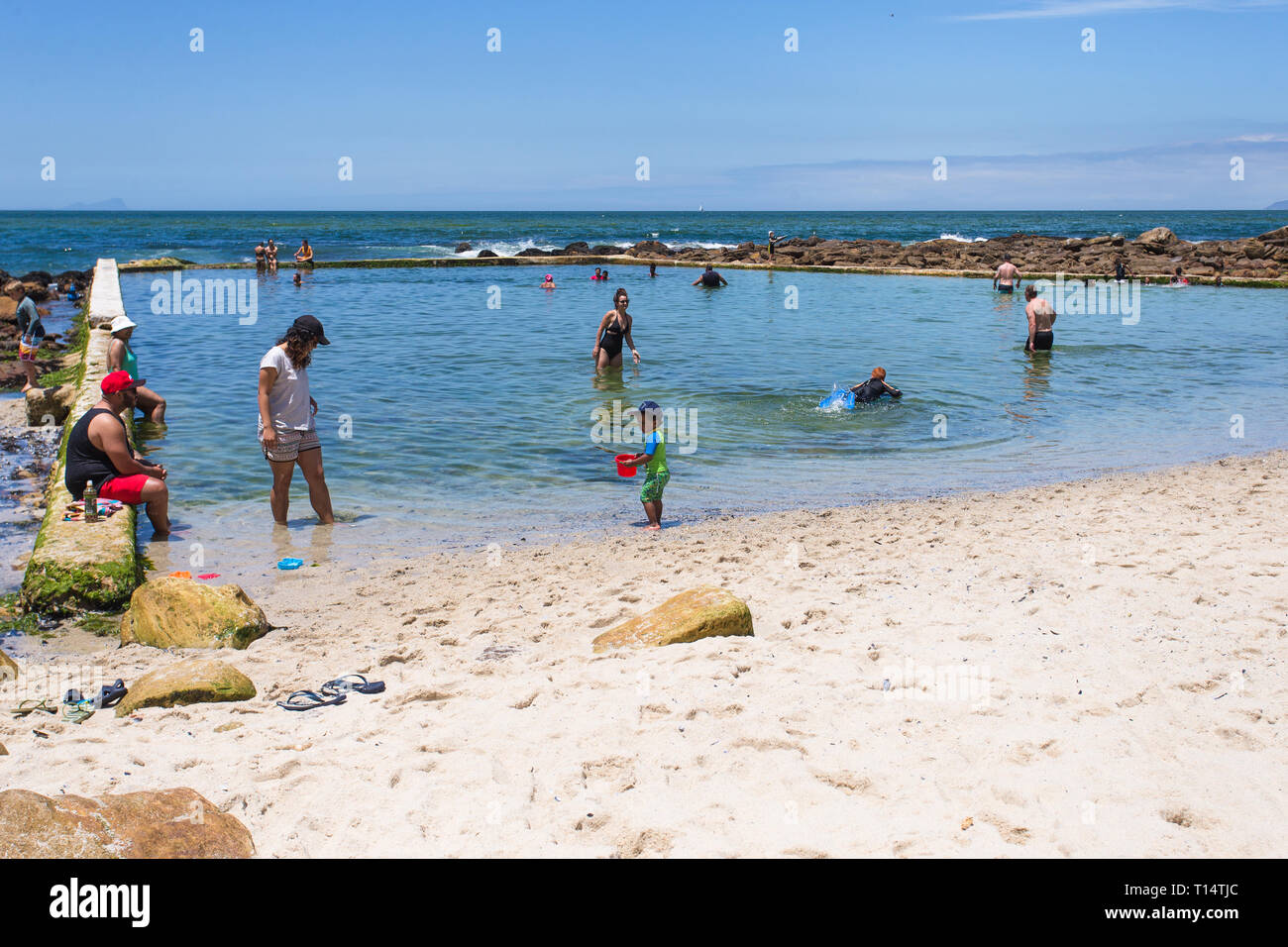 Tidal piscina presso il St James beach con persone il raffreddamento in estate in vacanza a False Bay, Cape Peninsula, Cape Town, Sud Africa Foto Stock