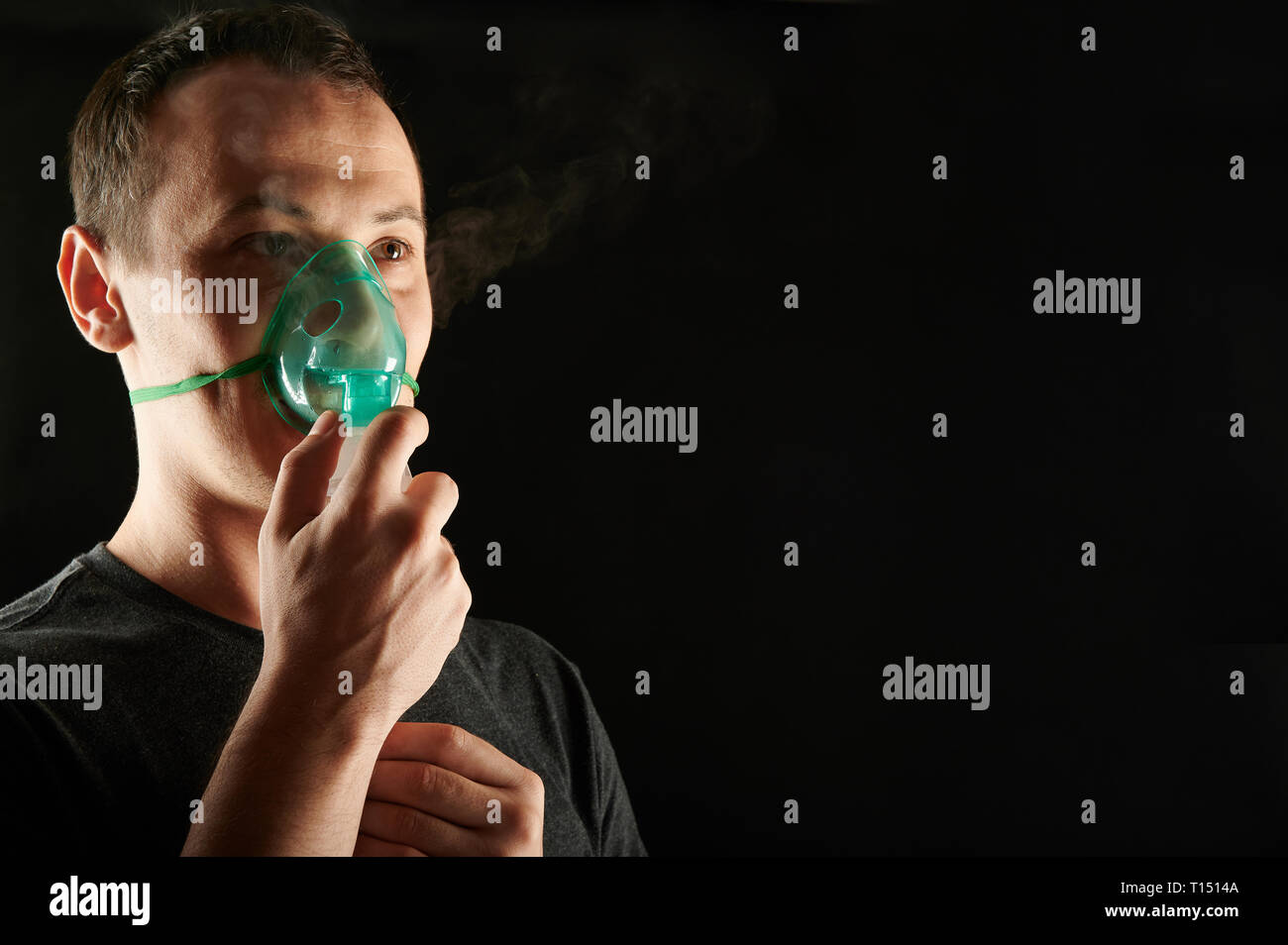 Uomo con maschera di inalatore isolati su sfondo nero Foto Stock