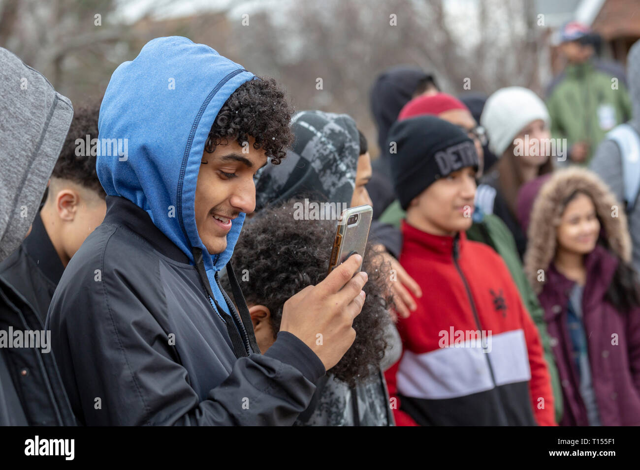 Hamtramck, Michigan - un giovane uomo in studi Hamtramck il suo telefono cellulare. Hamtramck è sempre stata una città di immigrati, più recentemente dal conteggio musulmano Foto Stock