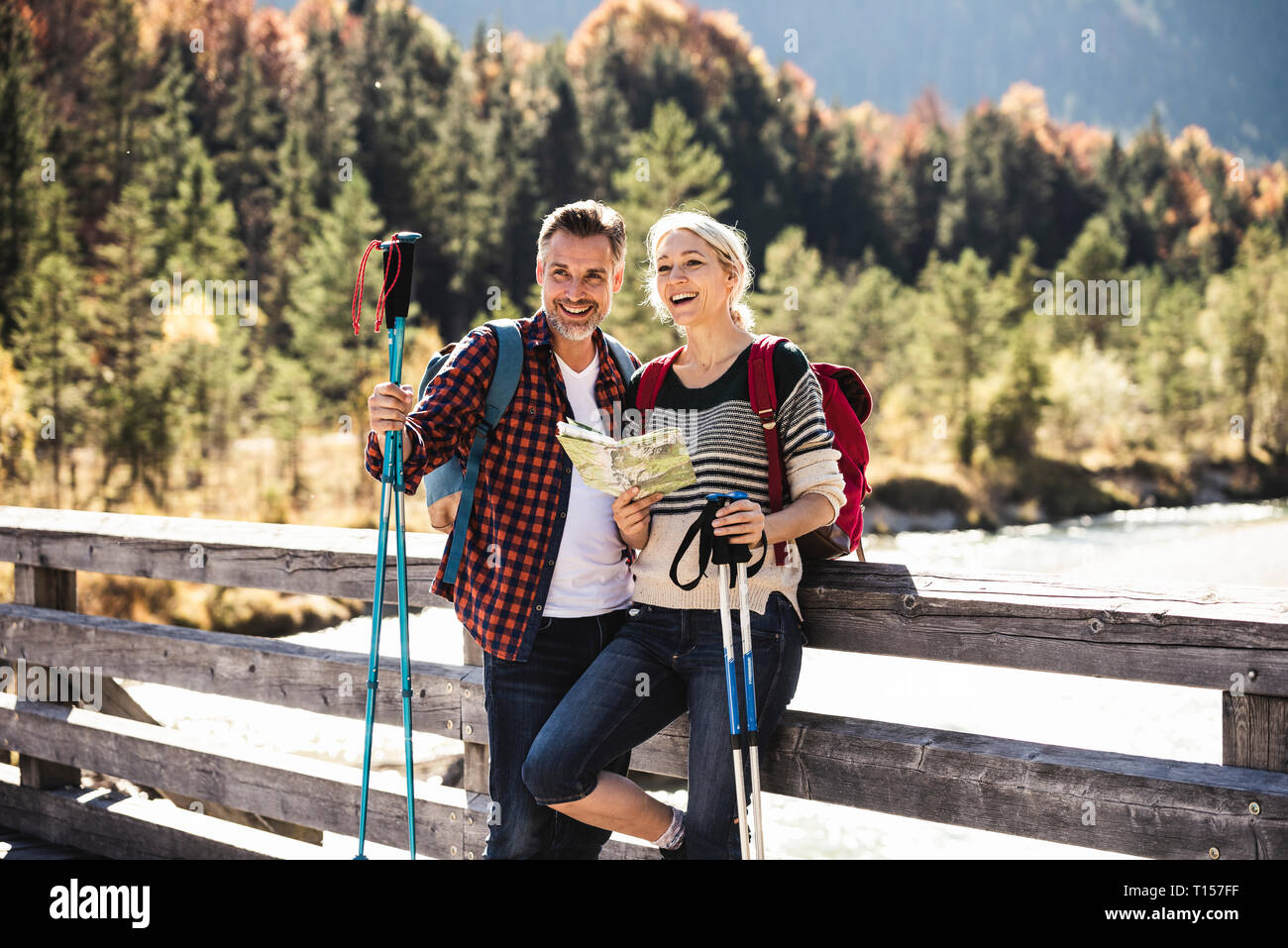 Austria, Alpi coppia felice su una escursione con la mappa su un ponte Foto Stock