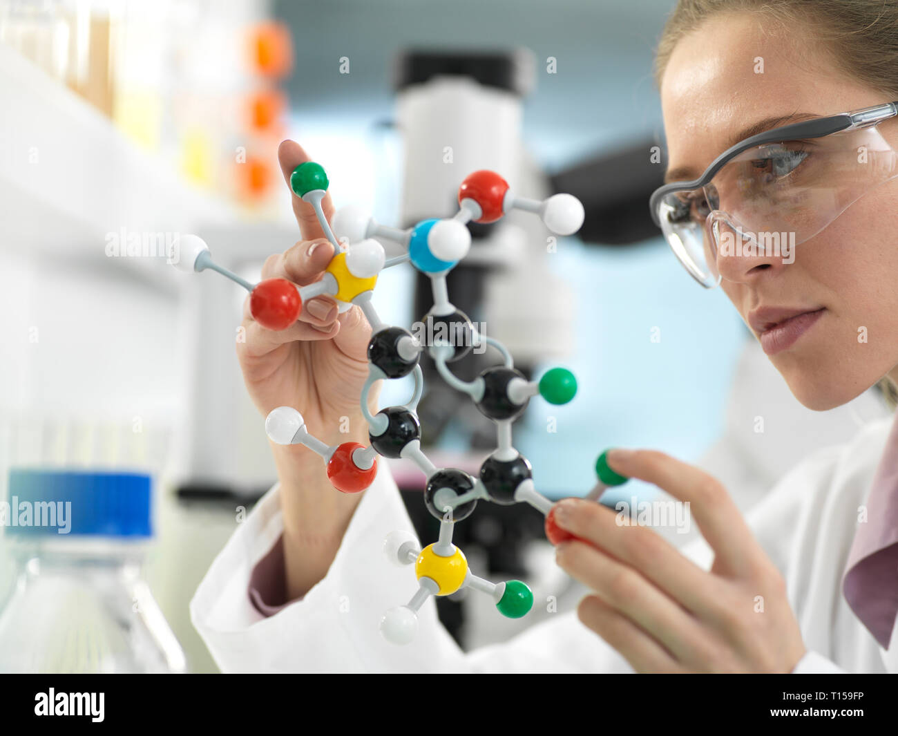 Scienziato esaminando un farmaco formula design utilizzando un modello molecolare in laboratorio Foto Stock