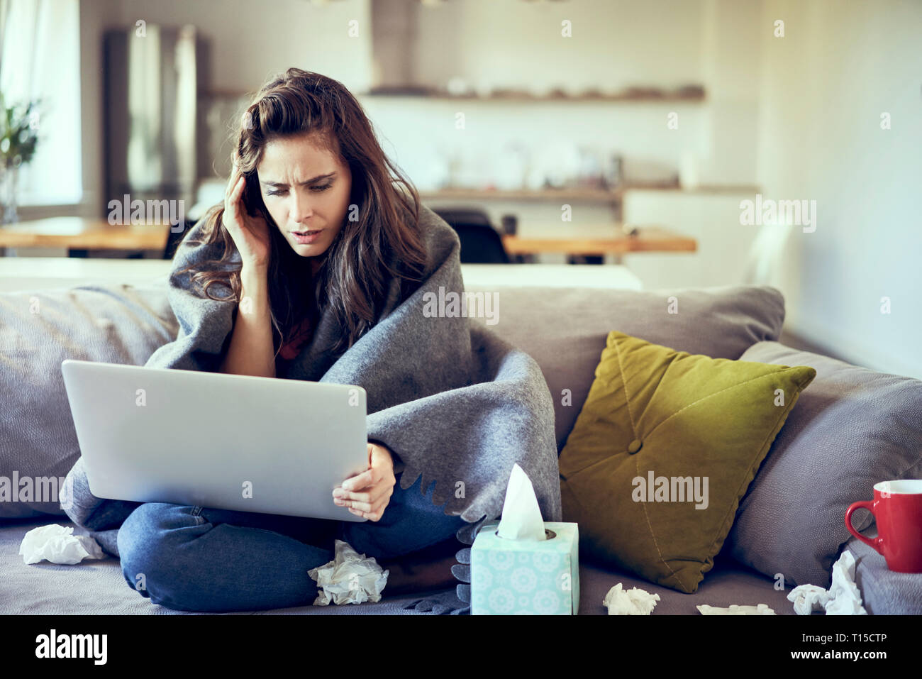 Malata cercando di lavorare da casa sul computer portatile Foto Stock