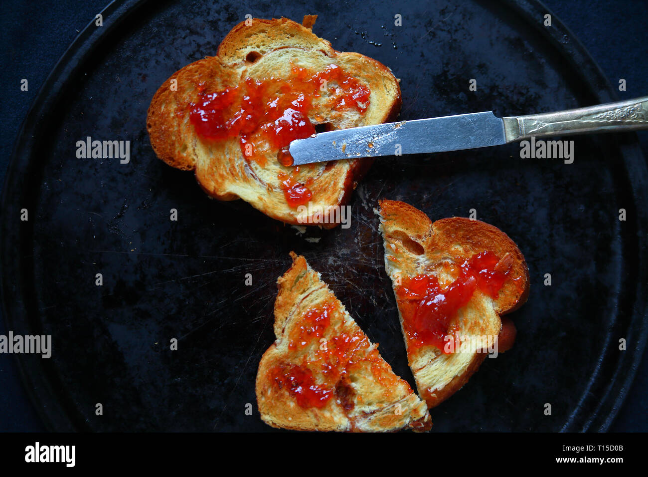 Sovraccarico di toast e marmellata su una vecchia teglia da forno Foto Stock