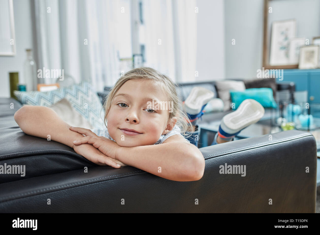 Ritratto di ragazza fiducioso sul lettino a casa Foto Stock