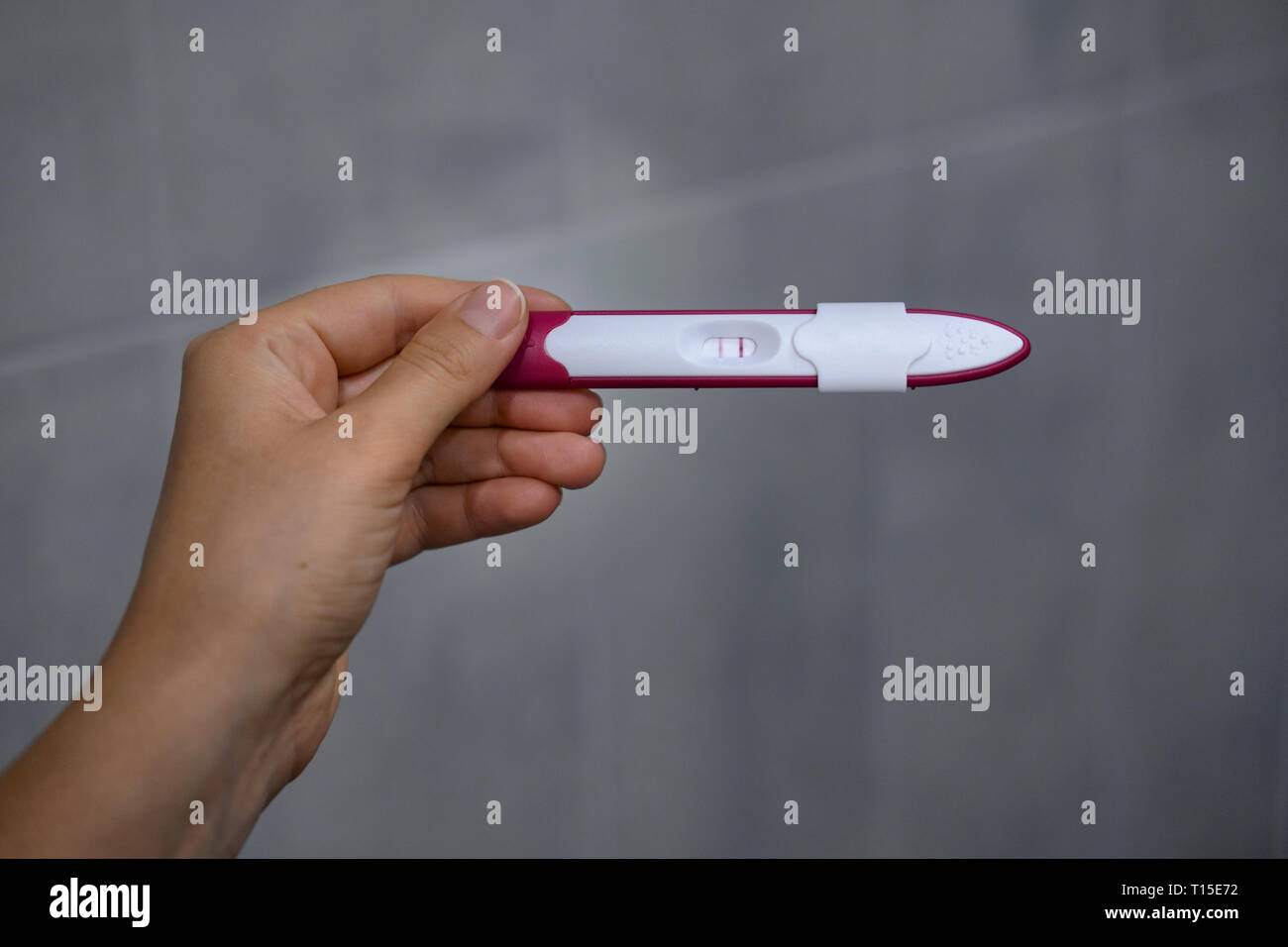 Close-up di donna di mani positivi ai test di gravidanza Foto Stock